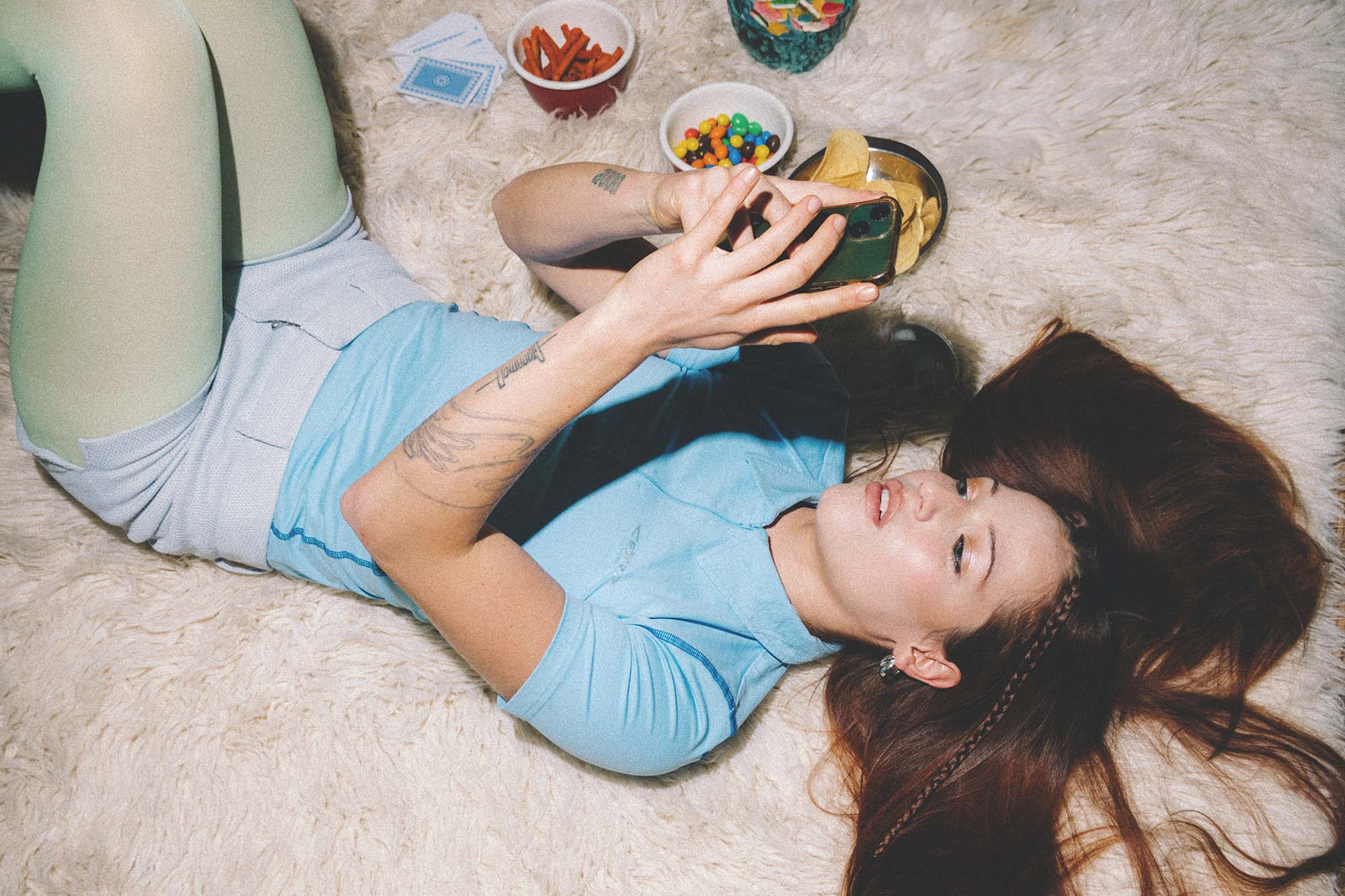 Girl laying on floor on phone. Every service is curated for individuals who value their wellbeing as much as their style